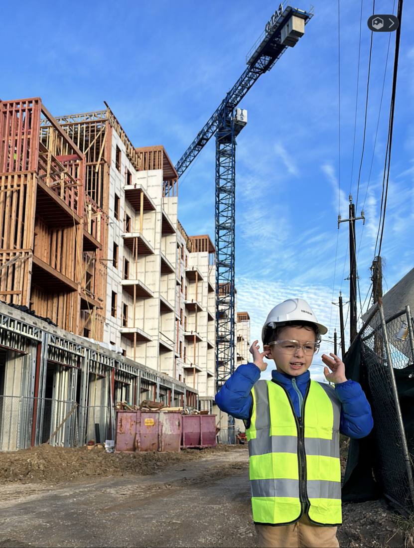 Adrian's son in front of the Heights mid-rise under construction