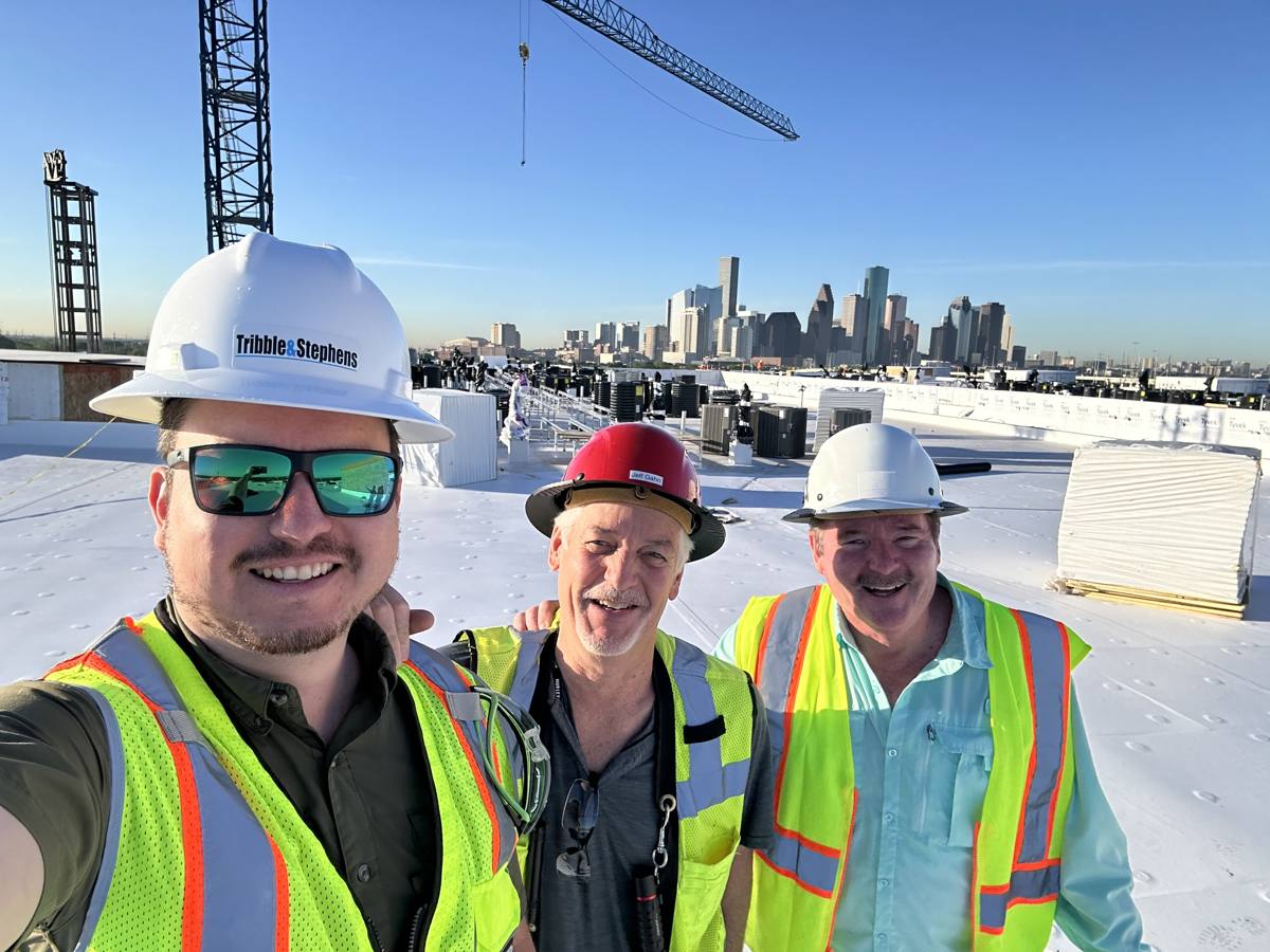 Adrian with the project team on the roof deck, downtown Houston skyline behind
